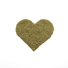 heart made of ground cannabis flower against a white background