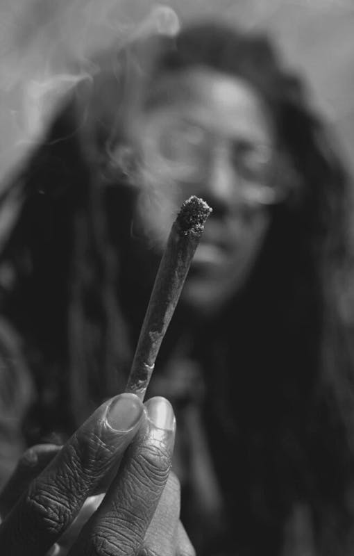 A man holds a lit joint in New York's Washington Square Park.