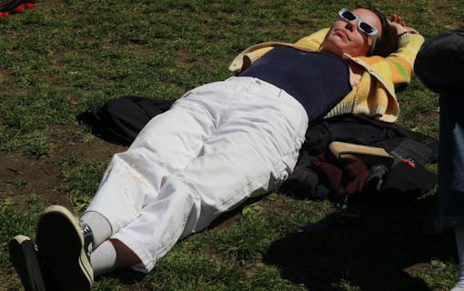 Woman relaxes in New York City's Washington Square Park during The Astor Club's massive 420 smoke session.