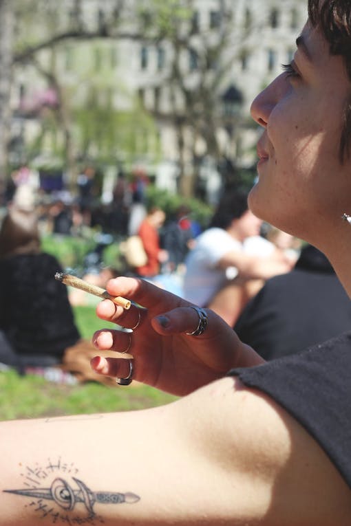 A woman smokes a lit joint in New York's Washington Square Park.
