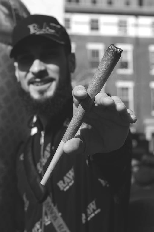 A man holds a jumbo RAW joint in Washington Square Park.