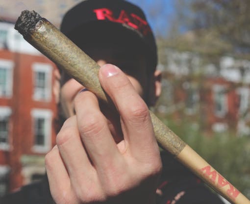 A man holds a jumbo RAW joint.