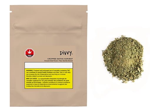 beige package of flower next to a pile of ground green weed