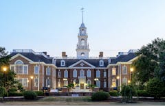 external photo of the brick Delaware capitol building, lit by elegant lampposts at sunset