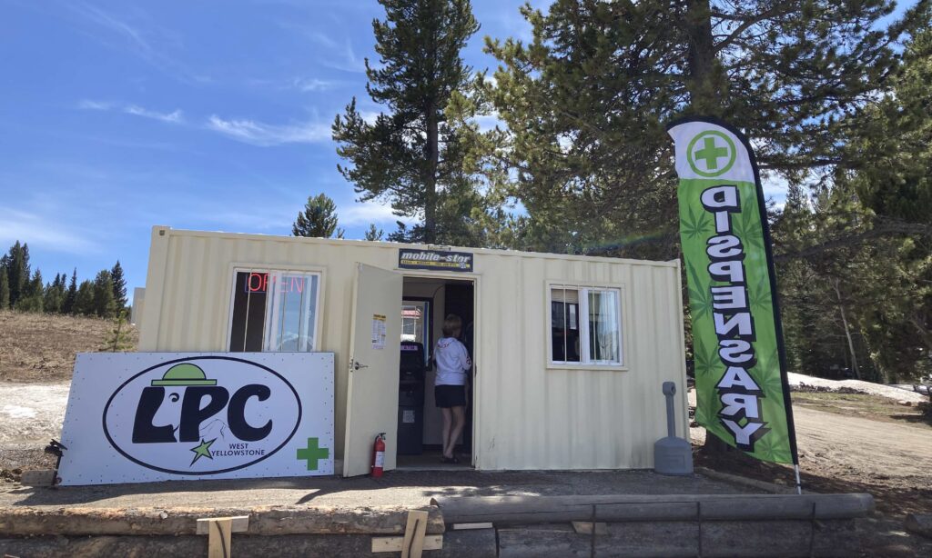 Shipping container pharmacy with big trees and blue sky began