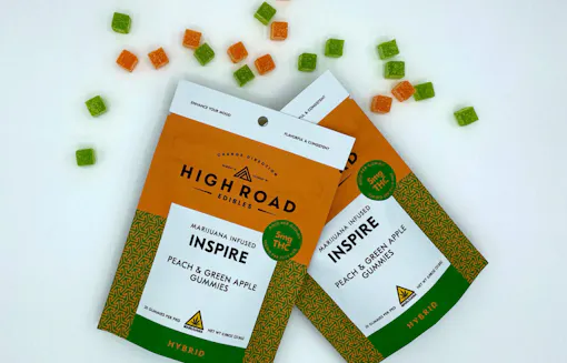 orange and green gummy packages, and individual gummies strewn around, against white background