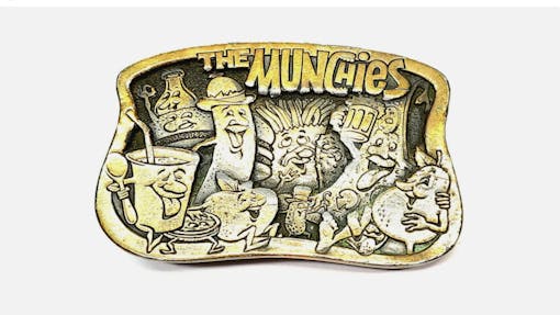 A belt buckle says "The Munchies" and shows food, like fries, pizza and an apple, acting stoned