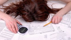 an image of a woman head down while doing her taxes