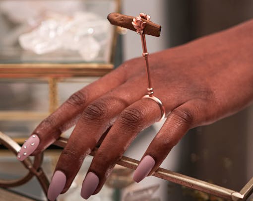a woman's hand and roach clip ring