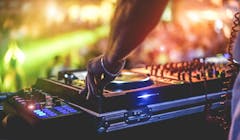 Dj mixing outdoor at beach party festival with crowd of people in background - Summer nightlife view of disco club outside - Soft focus on hand fingers - Fun ,youth,entertainment and fest concept