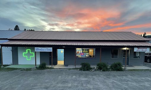 long, low-slung green-gray dispensary at sunset