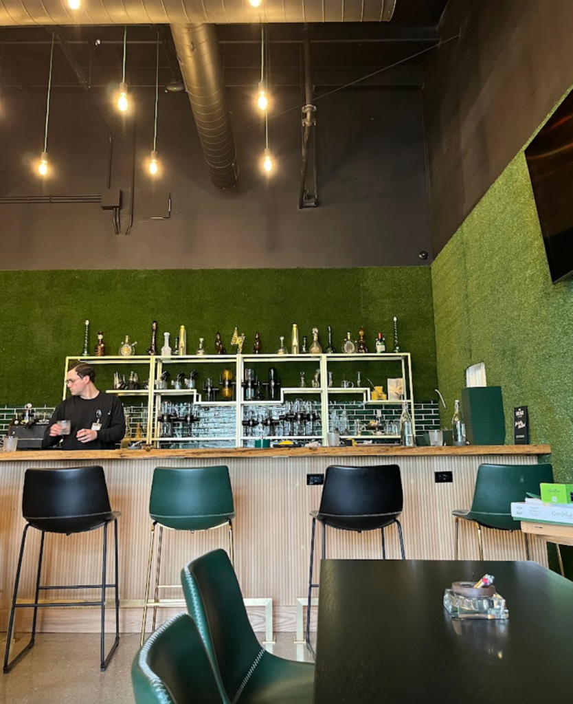 RISE dispensary lounge with green walls, chairs, a bar