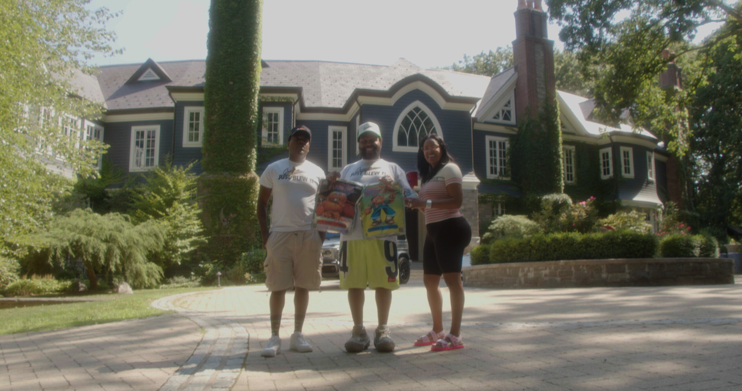 Luka Brazi and Alexis Major, aka Mr. and Mrs. GUMBO, pose in front of their New York estate with Leafly contributor MIkhail Harrison.(Jon Bain / Leafly)