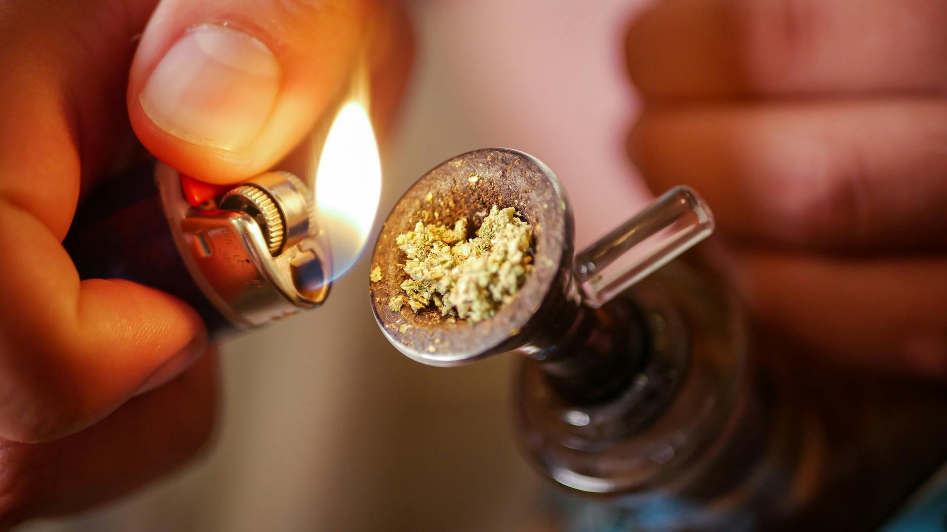 hand putting a lighter to a bowl