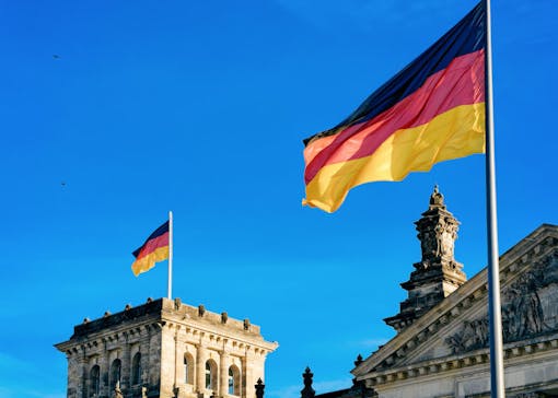 Reichstag building architecture with German Flags in Berlin city center, capital of Germany in winter in the street. German Bundestag parliament house.