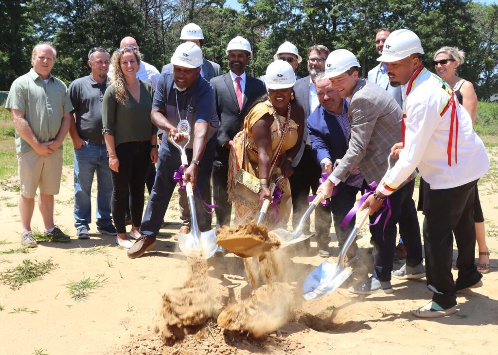 Chenae Bullock (center), manager of Little Beach Harvest, along with members of TILT Holdings and the Shinnecock tribe, lays the foundation stone for the future site of the country's cannabis dispensary and wellness center on July 11, 2022.