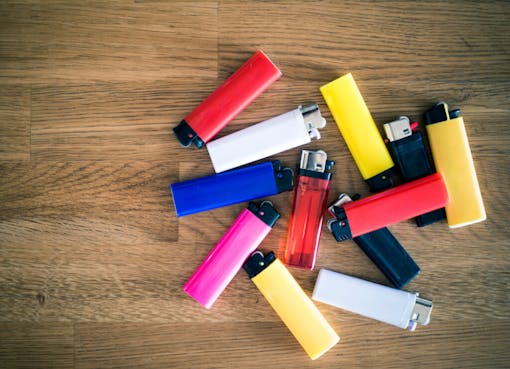 still-life with multiple lighters scattered on a wooden floor