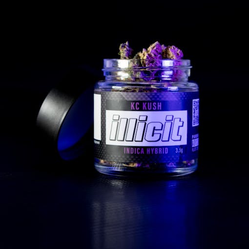 Photo of Illicit KC Kush on black background. Lid is off the jar, showing flower and label reads "Illicit KC Kush Indica Hybrid"