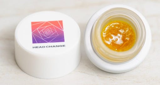 Photo of a jar of Head Change sugar with the lid off showing cannabis sugar concentrate