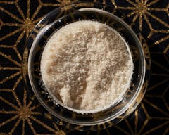 closeup of nearly white contentrate against a black and gold background