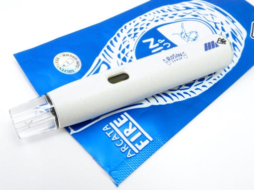 Close-up of a white disposable vape pen resting on its bright blue packaging