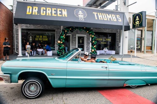 teal low-rider parked in front of Dr. Greenthumb's store