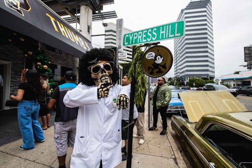 person in skeleton costume and lab coat outside of store