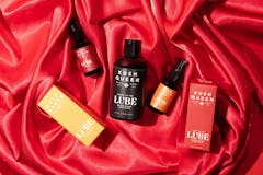 a handful of packages of lube against a red velvet-y background