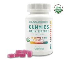 white jar of gummies with a few purple gummies in front of it