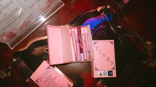 Pack of pink in front of the roll cannabis wrapped in rose leaves