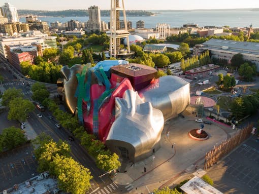 Aerial view of the Seattle Center, featuring the iconic Museum of Pop Culture (MoPOP) with its unique, modern architecture. City streets and surrounding parkland are visible. Seattle, Washington, USA